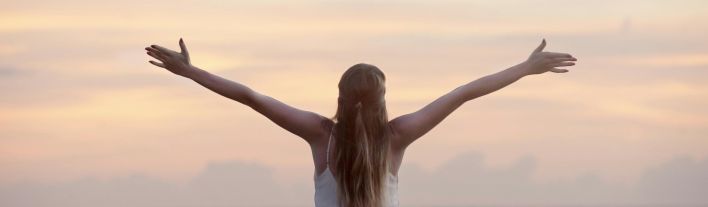 A woman enjoying a serene sunset on Unawatuna Beach, Sri Lanka, depicting peace and freedom.